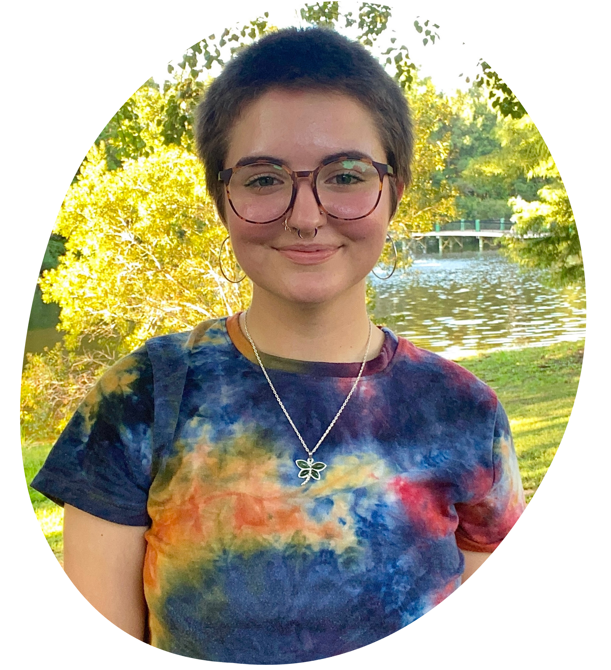 Casual headshot portrait of Rachell Skinner: Short haired woman with glasses standing outside.